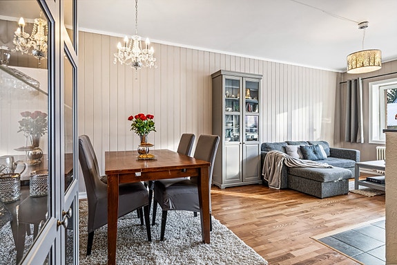 Lys stue med plass til både sofagruppe, TV-møblement og spisebord.