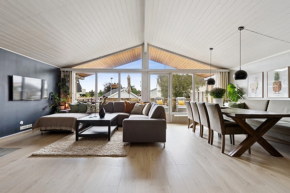 Romslig stue som måler 35 kvm. God takhøyde og store vindusflater gir rommet en luftig følelse.