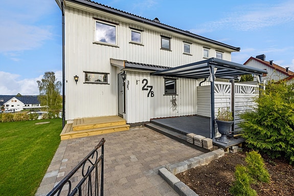 Ved inngangspartiet er det en vestvendt, overbygd terrasse med plass til en lounge.