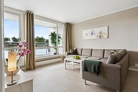 Romslig stue med store vindusflater og utgang til stor terrasse på 16,8 kvm