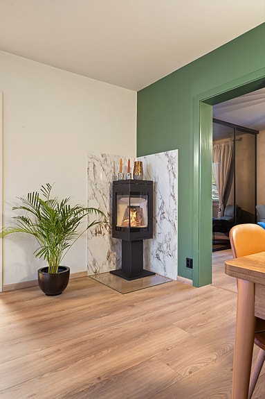 Vedovn type Nordpeis med glassplate på gulv fra 2023. Pipen er flislagt.