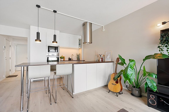 Stilrent og moderne kjøkken med integrerte hvitevarer og praktisk kjøkkenøy