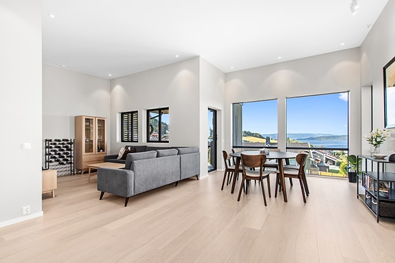 Romslig stue med god plass for flere sittegrupper.