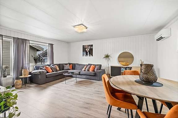 Lys og moderne stue med utgang til sjarmerende spiseområde.