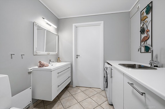 Moderne baderomsinnredning og opplegg for vaskemaskin, romslig bad.