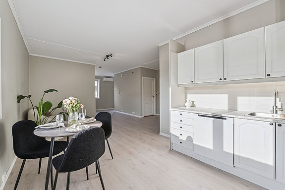 Pent kjøkken med profilerte fronter og laminat benkeplate.
