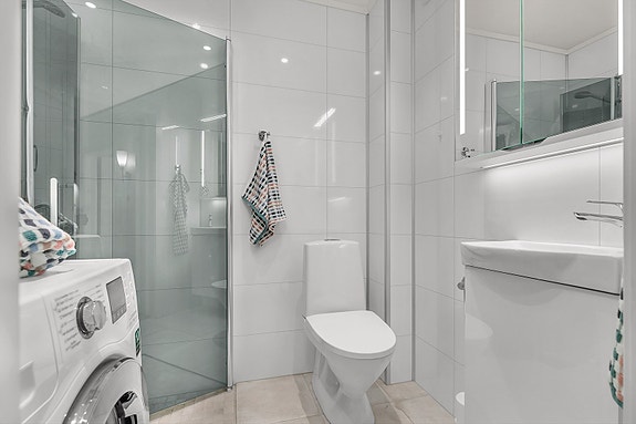 Bad i tidløse farger med flislagt gulv med varmekabler.