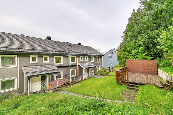 Tomten er opparbeidet med plenareal, plattinger og forstøtningsmurer.