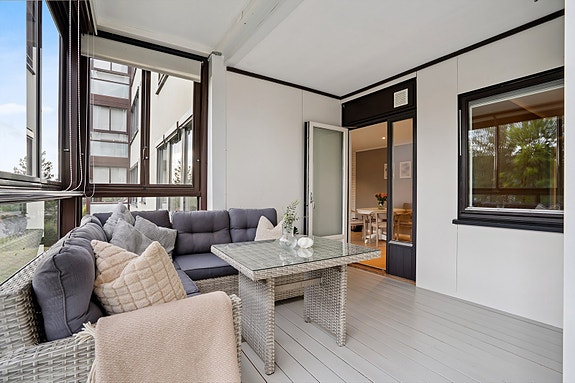 Romslig innglasset balkong fungerer som en forlengelse av stuen, sommer som vinter!