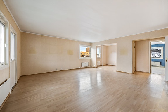 Lys og moderne stue med god plass til møblering og spisebord.