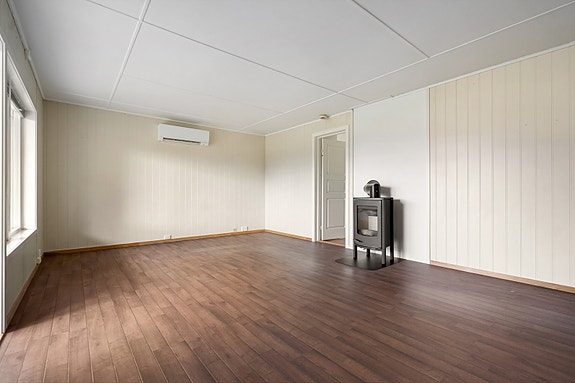 Stuen er utstyrt med både vedovn og varmepumpe - en kombinasjon som gir rimelig oppvarming og en lun atmosfære hele året