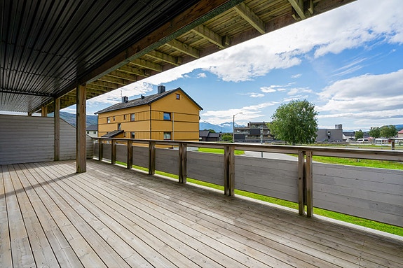 Her kan du nyte lange sommerdager på en romslig terrasse med takoverbygg og fin utsikt mot nærområdet