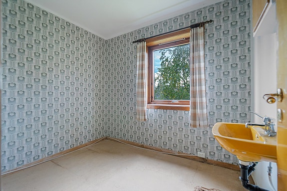 Soverom i kjeller med servant. Rommet har behov for oppgradering