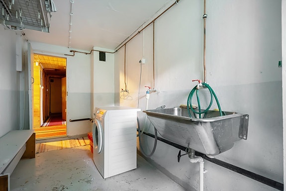 Vaskerom i kjelleren med opplegg til vaskemaskin og praktisk vask. Det er også et toalettrom i kjeller