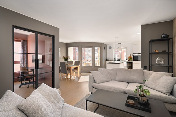 Lys og romslig stue med store vindusflater som slipper inn rikelig med naturlig lys. Industridøren til kontor/soverom gir rommet et moderne og eksklusivt preg.
