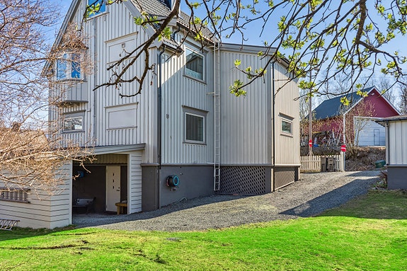 Utvendig - her er det carport med inngangsdør til kjelleretasje.