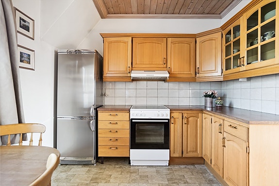 Kjøkkenet har innredning med profilerte fronter, benkeplaten er av laminat.