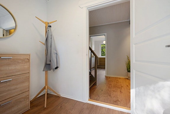 Lys entré som ønsker deg velkommen inn - her er det plass til oppbevaring og oppheng av yttertøy