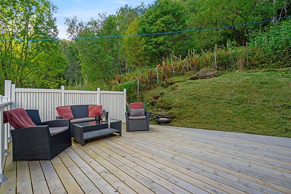 Terrassen ved inngangspartiet ligger lunt til med skjerming mot skogen bak