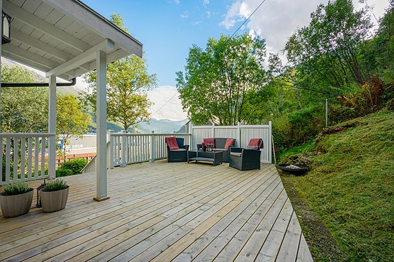 Her er det god plass til både sittegruppe, grill og utemøbler - her kan du sitte i le for naboer og nærhet til naturen