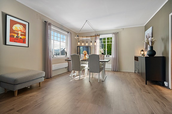 Koselig spisestue som er godt plassert med to vindu som slipper inn rikelig med lys og skaper en hyggelig stemning rundt bordet