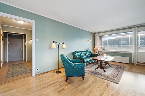 Lys og romslig stue med utgang til innglasset balkong