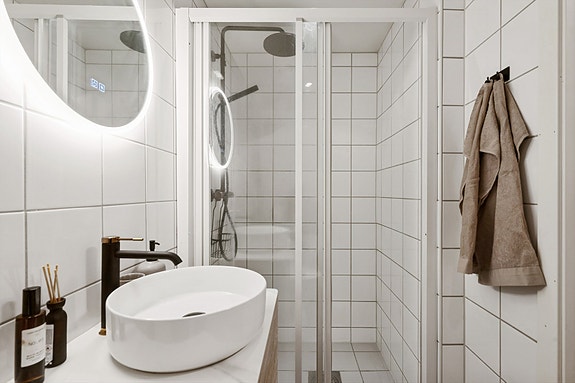 Baderomsinnredning med servant, speil og dusjbatteri ble byttet i 2024.