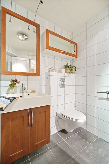 Badet har innredning med nedfelt servant, veggmontert toalett, dusjhjørne samt opplegg for vaskemaskin.