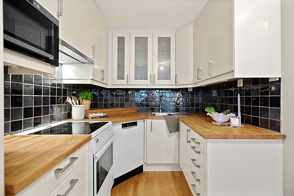 Kjøkket har lyse, slette fronter med benkeplaten av heltre.