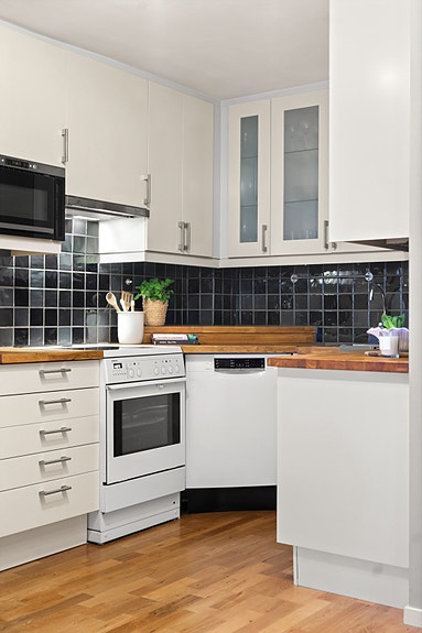 Kjøkkenet inneholder kjøl/fryseskap, oppvaskmaskin, komfyr, mikro og en kjøkkenventilator med avtrekk.