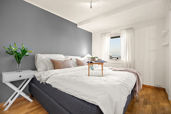 Romslig og innbydende soverom med god plass til dobbeltseng og nattbord.