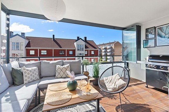 Solrik innglasset balkon med utemøblement