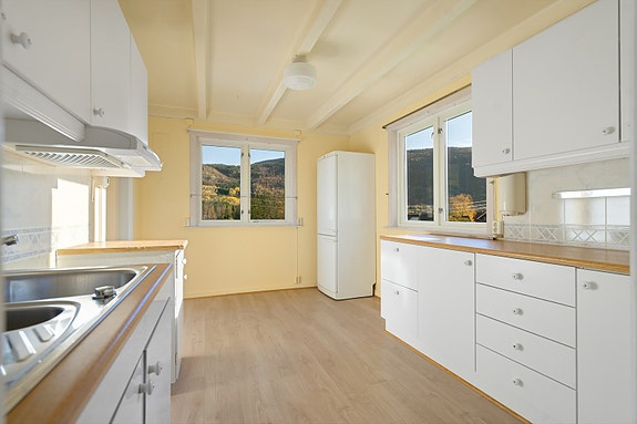 Kjøkkenet er lyst og praktisk med vinduer i to retninger som gir naturlig lysinnslipp og utsikt til hagen