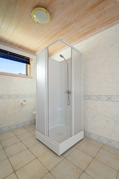 I badet er det dusjkabinett og opplegg for vaskemaskin