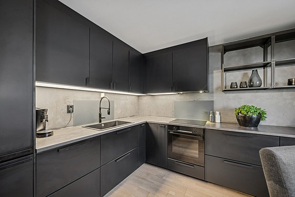 Kjøkkenet er utstyrt med integrert stekeovn, koketopp, oppvaskmaskin og kjøleskap med fryser.