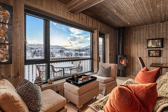 Stue med store vindusflater som slipper dagslyset inn