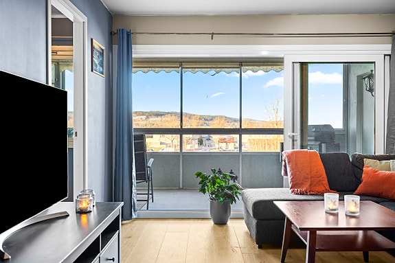 Skyvedøren i glass visker ut skillet mellom inne og ute, og gir direkte tilgang til balkongen.