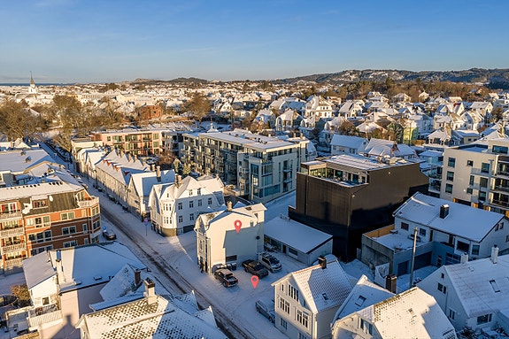Eiendom med prosjektert leilighetsbygg og eksisterende hjørnehus med 2 boliger og næringlokale