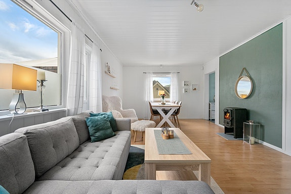 Lys og trivelig stue med store vindusflater som slipper inn rikelig med dagslys