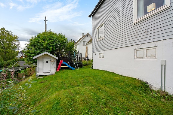 Barnevennlig hage med god boltreplass, trampoline og en sjarmerende lekestue som gir glede for familiens minste