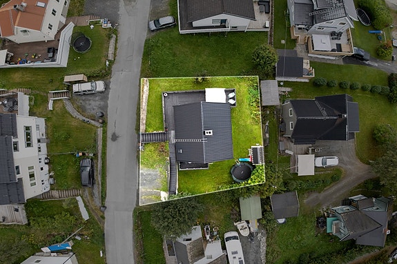 Oversiktsbilde som viser eiendommen ovenfra - gode uteområder med hage og terrasse
