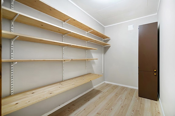 Bod med adkomst fra gang. Fastmonterte hyller gir god oversikt og orden i oppbevaring.