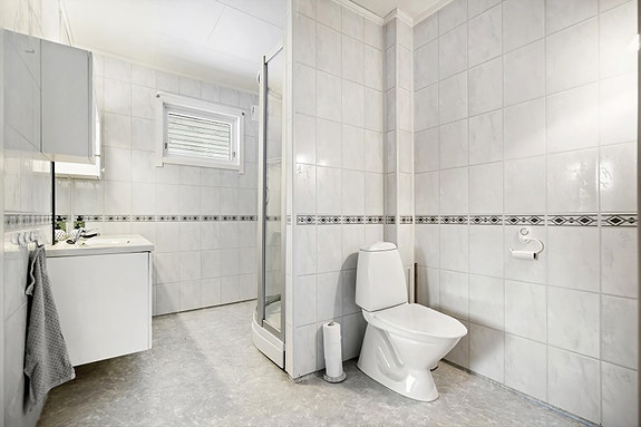 Bad 1 etg. - Rommet har heldekkende servant, dusjkabinett og toalett. Baderomsinnredning med lys og speil, servantskap og overskap som gir godt med oppbevaring.