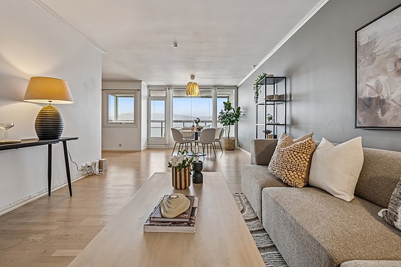 Lys og romslig stue med store vindusflater og utgang til balkong. Moderne og stilrent design som innbyr til trivsel.
