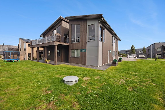 Pent opparbeide uteområder med bla. plen, beplantninger og belegningsstein.