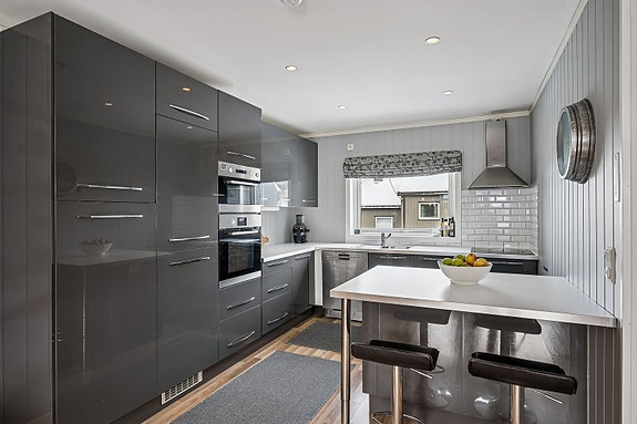 Flott kjøkken fra IKEA (2012). Slette fronter og benkeplate i laminat, legg også merke til downlights i tak.