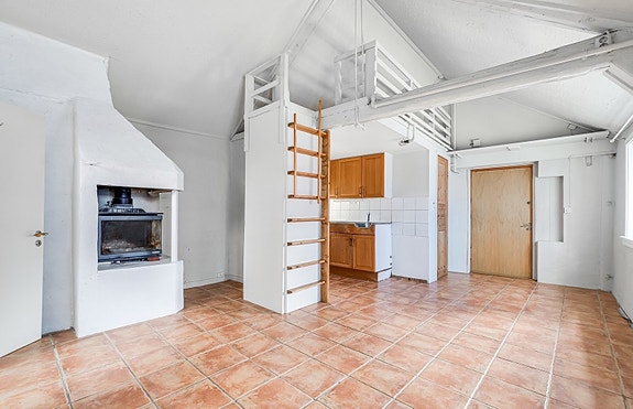 Stue med peis, hens og varme i gulv.