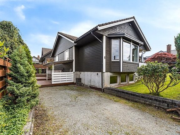 Fasade og parkeringsplass. Hybelen befinner seg i sokkeletasjen.