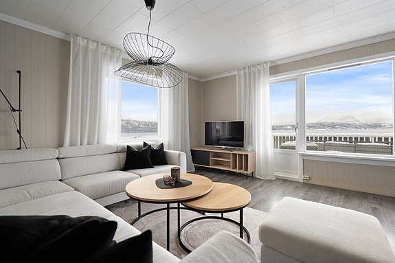 Stuen har store vindusflater som slipper inn rikelig med dagslys samt en fantastisk utsikt