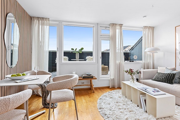 Leiligheten har en åpen stue- og kjøkkenløsning med direkte utgang til en privat takterrasse.